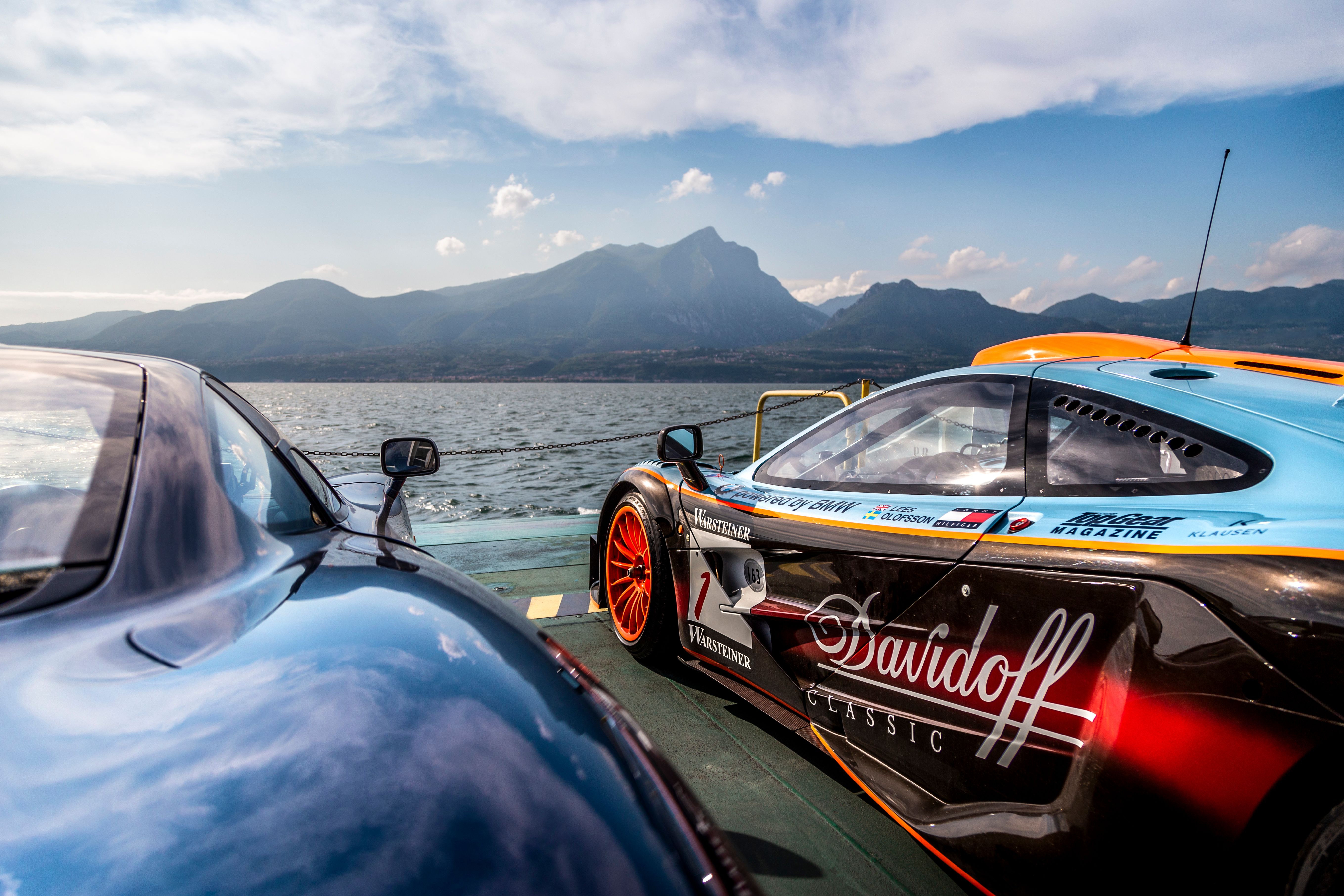 McLaren F1 GTR in Gulf livery on a lake ferry beside a road going McLaren F1